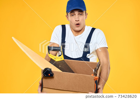 worker with box in hand tools loader yellow background 73428620