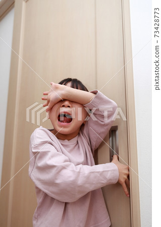 A girl who gets injured by pinching her hand when opening and closing the door A girl who gets injured by pinching her hand when opening and closing the door 73428773