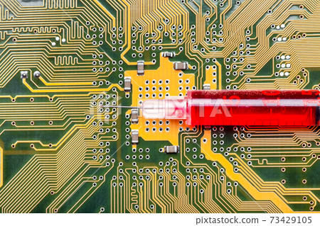 syringe with needle filled red medicinal product lies on silicone printed circuit board with contact tracks of electronic equipment of modern medicine vaccine cyber implantation treatment. syringe with needle filled red medicinal product lies on silicone printed circuit board with contact tracks of electronic equipment of modern medicine vaccine cyber implantation treatment. 73429105