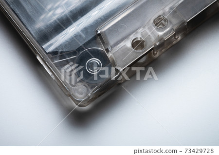 Close-up of a classic audio cassette tape with magnetic tape inside. Retro background Close-up of a classic audio cassette tape with magnetic tape inside. Retro background 73429728