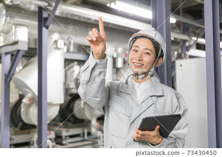 Business woman performing equipment maintenance at factory facilities 73430450