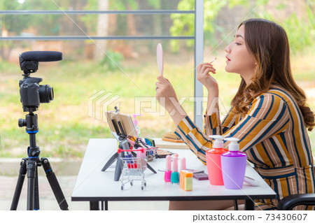 Beautiful young Asian woman making online product review at home 73430607