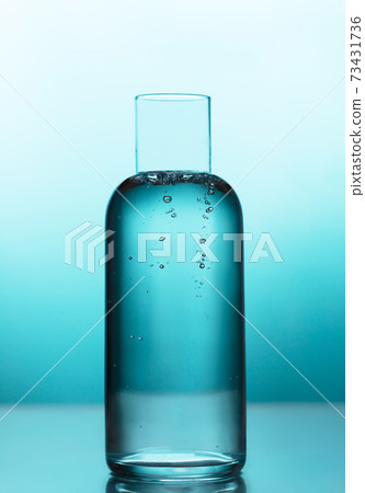 Fresh water with bubbles in a jug on the blue background 73431736