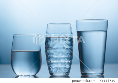 Fresh water in a three glasses on the blue background Fresh water in a three glasses on the blue background 73431739