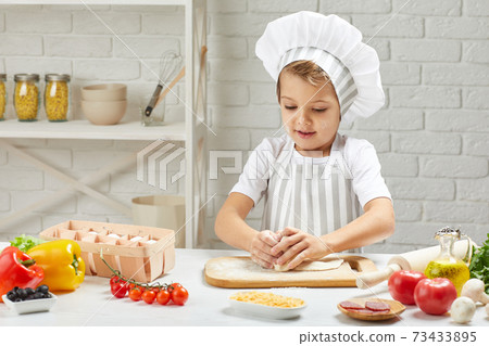 little child boy in cap and an apron cook little child boy in cap and an apron cook 73433895