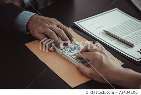 Businessmen give dollars to bribe employees in signing contracts to buy illegal land and real estate, Business fraud and social injustice, corruption and bribery concept. Businessmen give dollars to bribe employees in signing contracts to buy illegal land and real estate, Business fraud and social injustice, corruption and bribery concept. 73434106