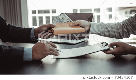Businessmen give dollars to bribe employees in signing contracts to buy illegal land and real estate, Business fraud and social injustice, corruption and bribery concept. Businessmen give dollars to bribe employees in signing contracts to buy illegal land and real estate, Business fraud and social injustice, corruption and bribery concept. 73434107