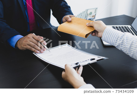Businessmen give dollars to bribe employees in signing contracts to buy illegal land and real estate, Business fraud and social injustice, corruption and bribery concept. Businessmen give dollars to bribe employees in signing contracts to buy illegal land and real estate, Business fraud and social injustice, corruption and bribery concept. 73434109