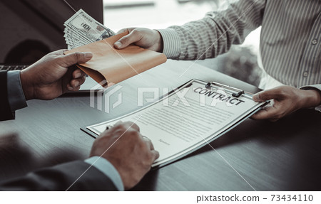 Businessmen give dollars to bribe employees in signing contracts to buy illegal land and real estate, Business fraud and social injustice, corruption and bribery concept. Businessmen give dollars to bribe employees in signing contracts to buy illegal land and real estate, Business fraud and social injustice, corruption and bribery concept. 73434110