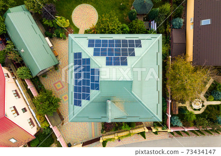 Aerial view of a rural private house with solar photovoltaic panels for producing clean electricity on roof. Autonomous home in residential area concept. Aerial view of a rural private house with solar photovoltaic panels for producing clean electricity on roof. Autonomous home in residential area concept. 73434147