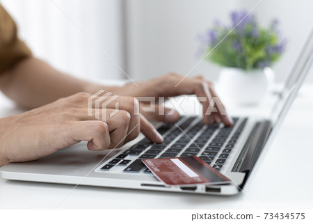Men use laptop to register online purchases using credit card payments, Convenience in the world of technology and the internet, Shopping online and banking online concept. Men use laptop to register online purchases using credit card payments, Convenience in the world of technology and the internet, Shopping online and banking online concept. 73434575