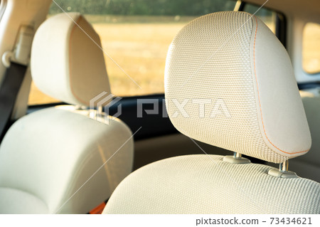 Closeup detail of light beige car headrests. 73434621