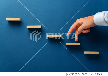 Businessman walking his fingers up a stairway 73435359