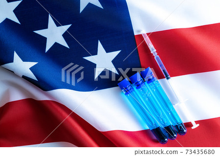 Injection usa. Medical syringe with needle for protection flu virus and coronavirus. Covid vaccine on american flag background. Concept fight against virus covid-19. Injection usa. Medical syringe with needle for protection flu virus and coronavirus. Covid vaccine on american flag background. Concept fight against virus covid-19. 73435680