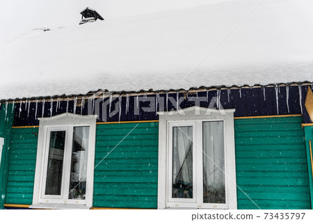 Ice icicles and Village house covered with snow, snowy winter, remote village, Russian village Ice icicles and Village house covered with snow, snowy winter, remote village, Russian village 73435797