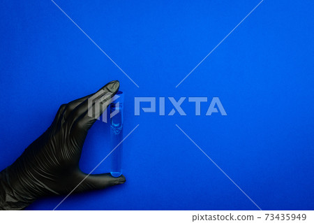 Syringe isolated. Doctor hand in medical glove hold test tube or bottle for protection flu virus and coronavirus. Covid vaccine isolated on blue. Concept fight against virus covid-19. 73435949