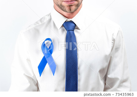 November. Hipster men in bright shirt, cyan tie with blue ribbon in hands on white background. Awareness prostate cancer of men health. Supporting people living and illness. 73435963