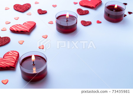 Saint Valentin background: red love hearts, romantic gift box, candle on white table. Romantic message template with copy space. Saint Valentin background: red love hearts, romantic gift box, candle on white table. Romantic message template with copy space. 73435981