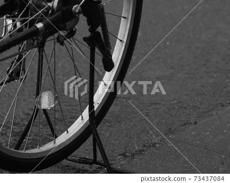 Rear wheels of a wet bicycle in the rain Rear wheels of a wet bicycle in the rain 73437084