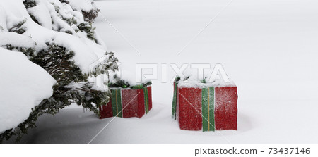 Two presants wrapped in red covered in snow outside next to a bush Two presants wrapped in red covered in snow outside next to a bush 73437146