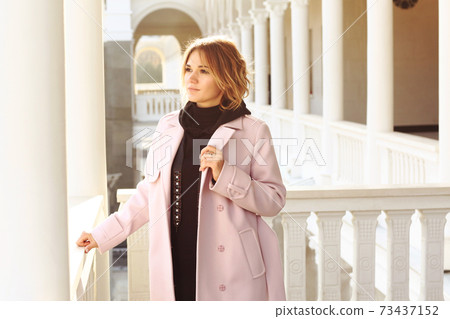blond business woman in pink coat close up photo on castle park architecture white background blond business woman in pink coat close up photo on castle park architecture white background 73437152