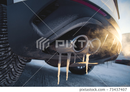 car exhaust pipe with smoke at shallow depth of field car exhaust pipe with smoke at shallow depth of field 73437407