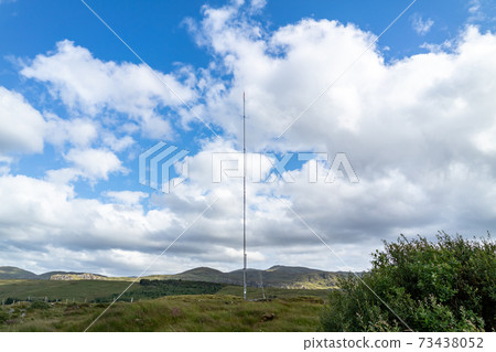 Street view of transmitter tower on an agricultural field in the irish highlands by Glenties in County Donegal Street view of transmitter tower on an agricultural field in the irish highlands by Glenties in County Donegal 73438052