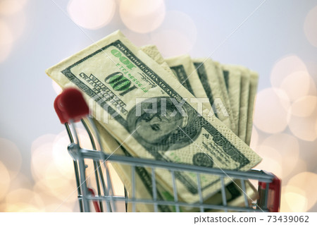 Shopping cart filled with one hundred dollars with bokeh background, business and finacial concept 73439062