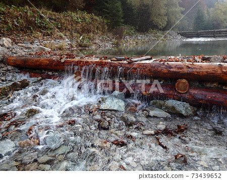 Wooden dam on a mountain river Wooden dam on a mountain river 73439652
