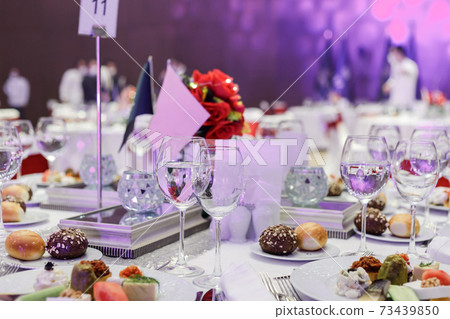 Festive round table setting in a prestigious restaurant for dinner. Banquet decoration with white and red 73439850
