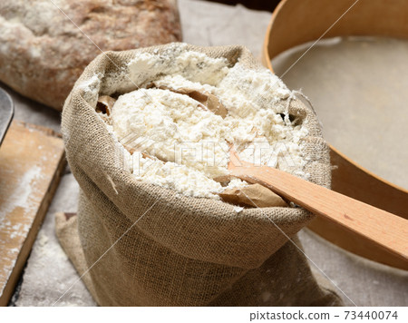 white wheat flour in a small burlap sack white wheat flour in a small burlap sack 73440074