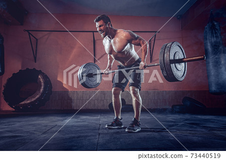 Muscular man working out in gym doing exercises, strong male naked torso abs Muscular man working out in gym doing exercises, strong male naked torso abs 73440519