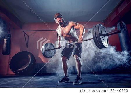 Muscular man working out in gym doing exercises, strong male naked torso abs Muscular man working out in gym doing exercises, strong male naked torso abs 73440520