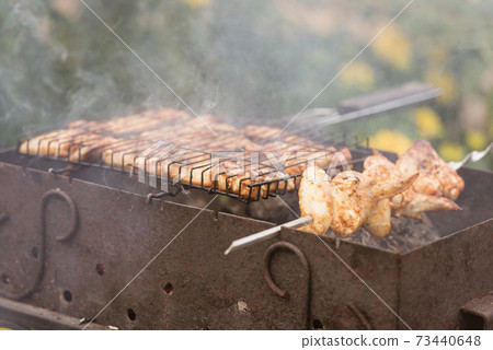Rusty grill and delicious meat. Barbecue on the grill and on the skewer. Rusty grill and delicious meat. Barbecue on the grill and on the skewer. 73440648