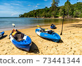 Blue kayaks on the beach 73441344