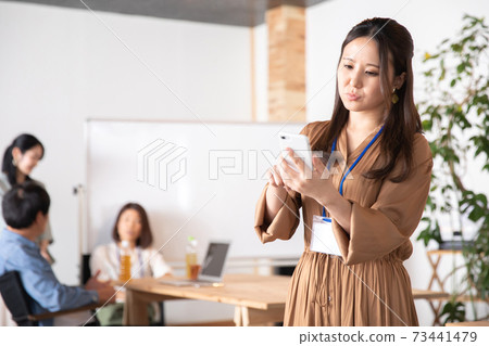 Business woman using a smartphone in the office 73441479