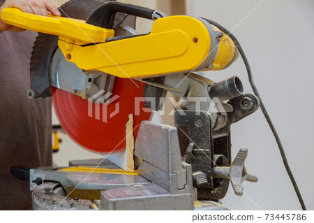 Close up of Circular saw cutting sharp rotary blade new baseboard woodwork Close up of Circular saw cutting sharp rotary blade new baseboard woodwork 73445786