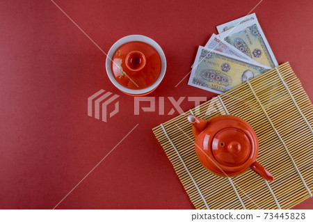 Celebrate Asian festival decorations Vietnamese New Year festive ceremony tea with Money Vietnamese dong on red background Celebrate Asian festival decorations Vietnamese New Year festive ceremony tea with Money Vietnamese dong on red background 73445828