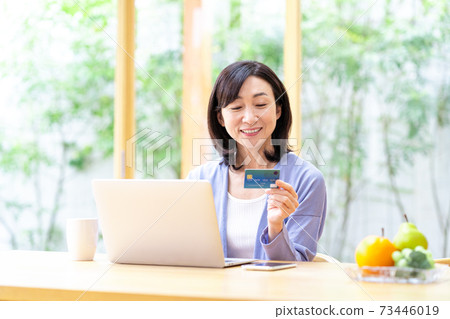 Middle woman using a computer in the living room Middle woman using a computer in the living room 73446019