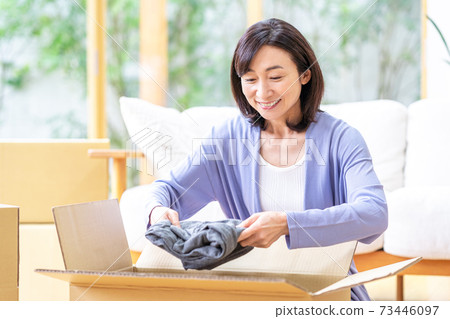 包裝在紙板在客廳裡的中年女人 73446097