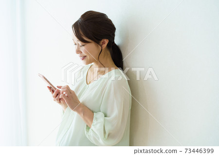 觀看智能手機的婦女 觀看智能手機的婦女 73446399