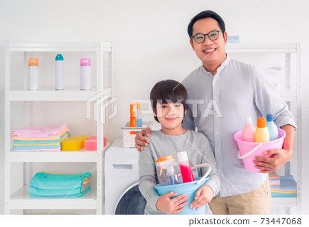 Father and Son holding bucket full of cleaning liquid bottles ready to do housework together. Father and Son holding bucket full of cleaning liquid bottles ready to do housework together. 73447068