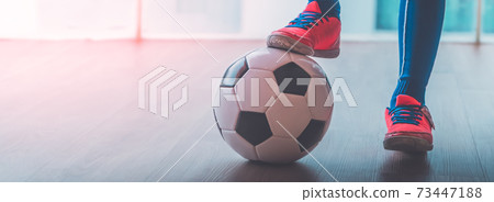 Soccer Kid feet stepping on a football for youth indoor sport. Soccer Kid feet stepping on a football for youth indoor sport. 73447188