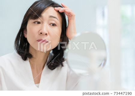 關心臉上的皺紋的中年女人 關心臉上的皺紋的中年女人 73447190