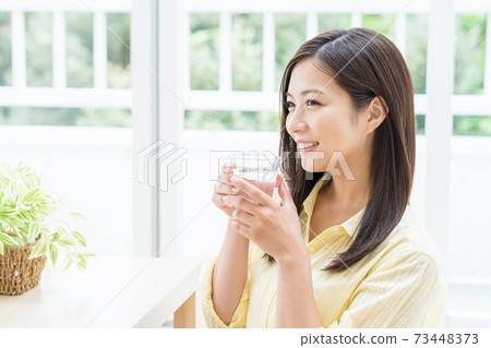 Young woman drinking water in the room 73448373