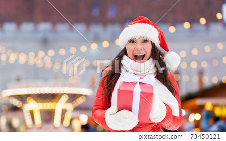 happy woman in santa hat with chrismas gift happy woman in santa hat with chrismas gift 73450121