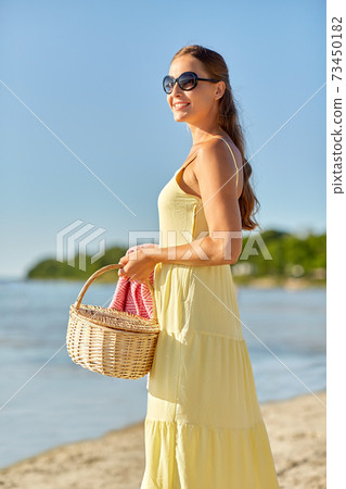 happy woman with picnic basket on summer beach 73450182