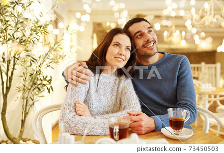 happy couple drinking tea at restaurant 73450503