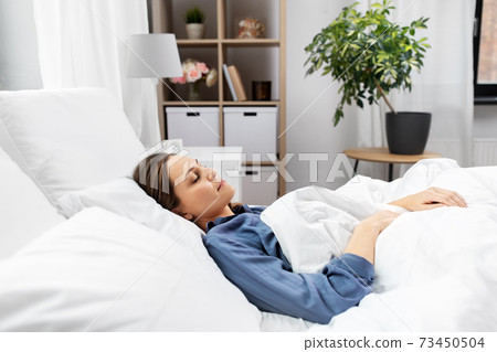 young woman sleeping in bed at home 73450504