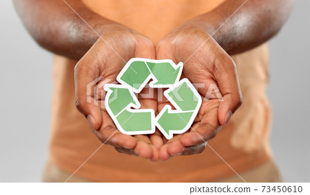 close up of man holding green recycling sign 73450610